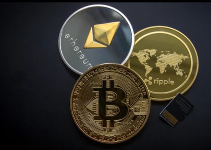 Imagem conceitual com moedas digitais representando Ethereum, Bitcoin e Ripple sobre fundo preto, simbolizando a infraestrutura da nova engenharia financeira global operando 24h por dia.