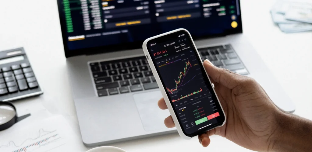 Tela de aplicativo de trading de Bitcoin com gráfico em tempo real sendo monitorado em smartphone