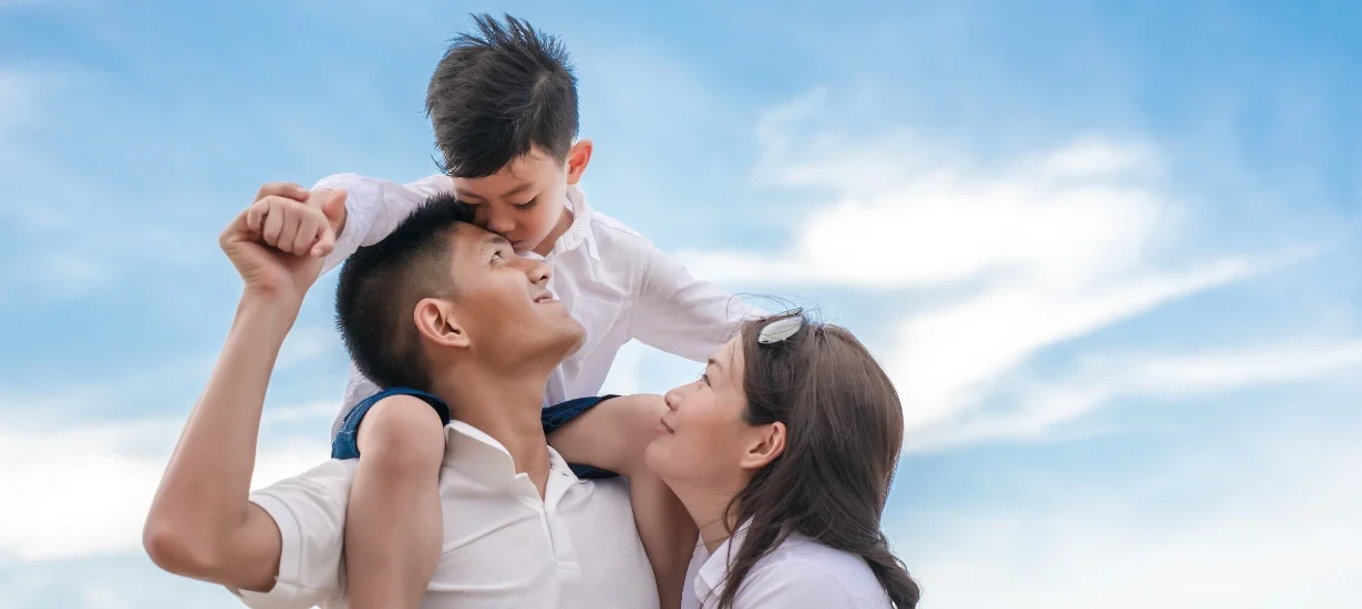 Imagem de família sorrindo ao ar livre, representando estabilidade financeira, segurança patrimonial e qualidade de vida através de investimentos em Bitcoin e renda passiva.