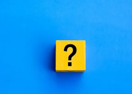 Bloco amarelo com ponto de interrogação sobre fundo azul, representando dúvidas fiscais em DeFi