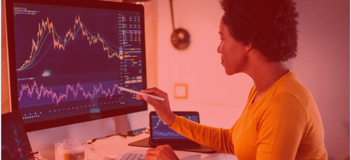 Trader analisando gráficos de mercado em tela grande, representando estratégia de rolagem e periodicidade na estratégia wheel com cripto