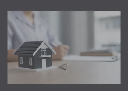 Miniatura de casa com chaves sobre a mesa e pessoa ao fundo, simbolizando análise de vantagens e desvantagens de imóveis tokenizados