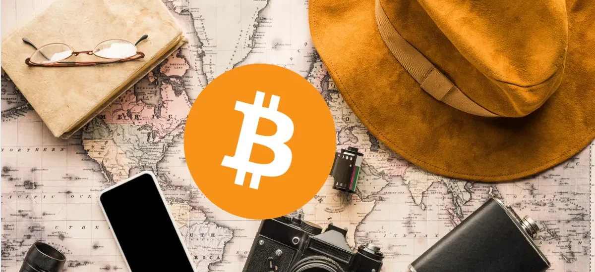 Viagem com Bitcoin — mapa, câmera e acessórios de viagem representando turismo com criptomoedas