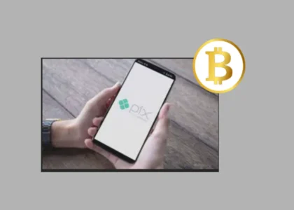 Pessoa segurando celular com tela do Pix ao lado do símbolo do Bitcoin, representando conversão rápida de reais para cripto