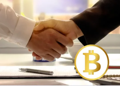 Duas pessoas apertando as mãos sobre contrato com símbolo do Bitcoin, representando herança e sucessão de criptoativos