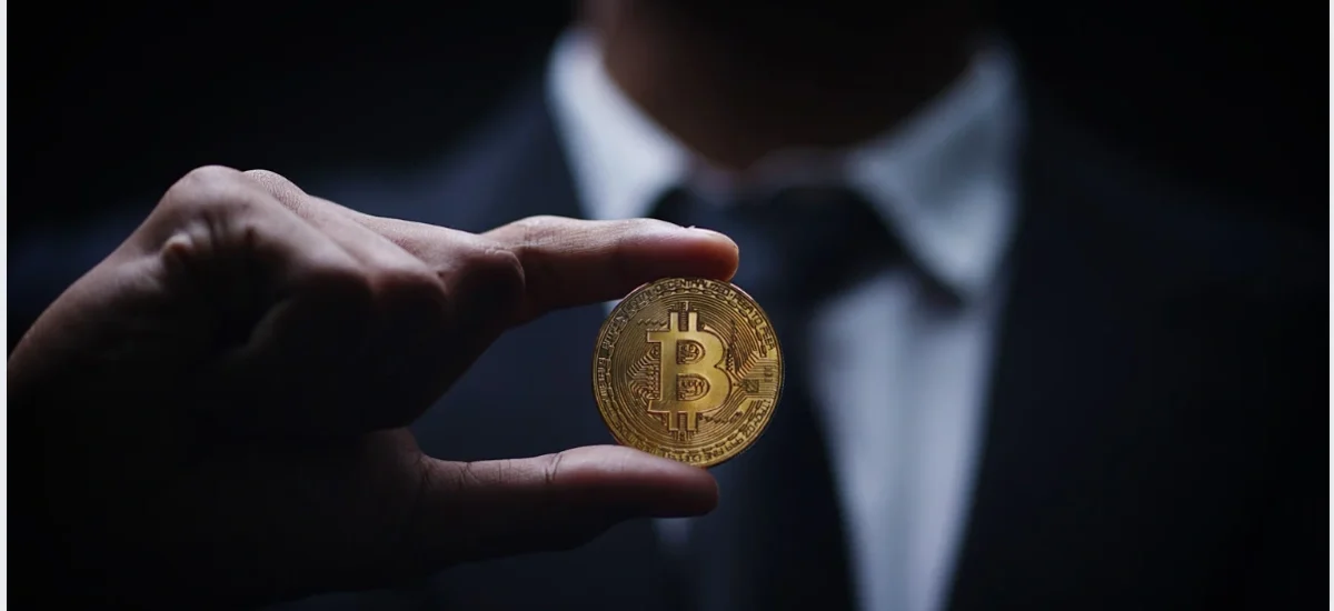 imagem mostrando uma pessoa segurando uma moeda física de Bitcoin, simbolizando operações de opções em mercados laterais