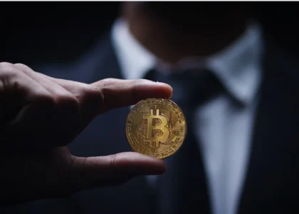 imagem mostrando uma pessoa segurando uma moeda física de Bitcoin, simbolizando operações de opções em mercados laterais