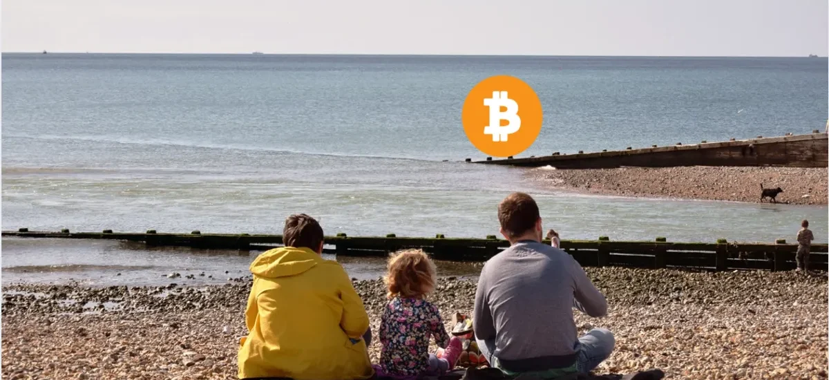 Família observando o mar com o símbolo do Bitcoin no horizonte, representando segurança, herança e continuidade financeira através de ativos digitais