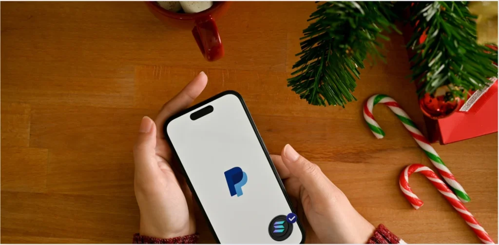 Pessoa segurando um smartphone com o aplicativo PayPal aberto, simbolizando pagamentos digitais rápidos e transferências globais com stablecoins