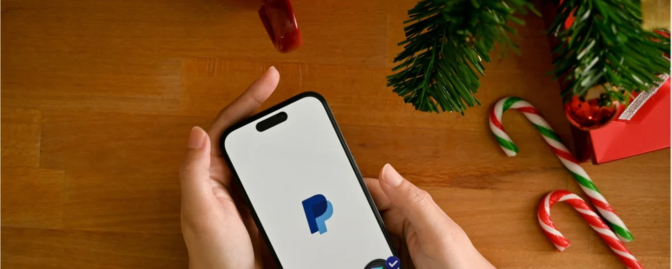 Pessoa segurando um smartphone com o aplicativo PayPal aberto, simbolizando pagamentos digitais rápidos e transferências globais com stablecoins